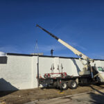 A crane lifting a commercial rooftop AC unit by Missouri Furnace & Air Conditioning.