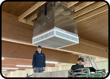 Two Missouri Furnace & Air Conditioning employees installing a commercial HVAC system in O'Fallon, MO.